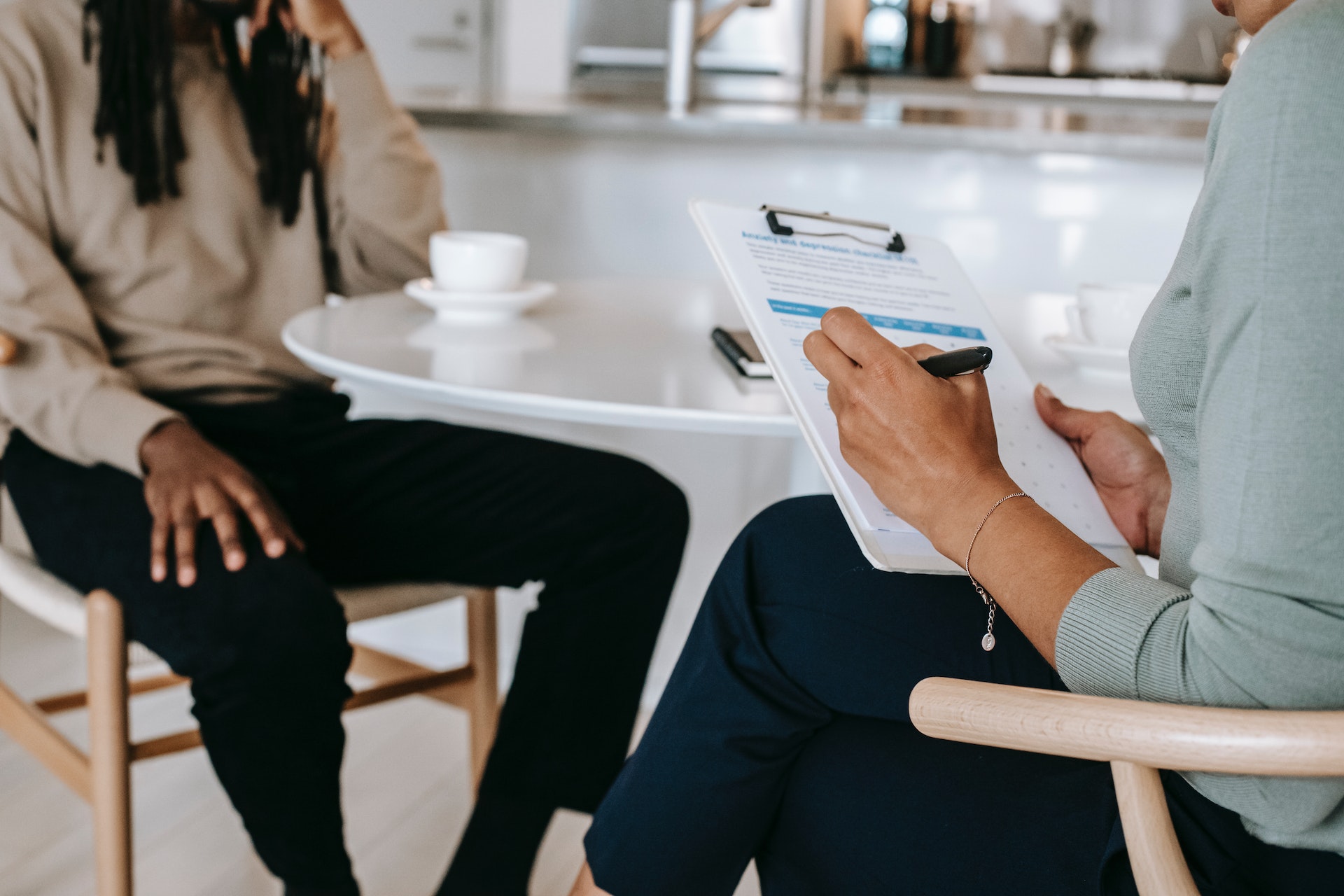 Two people having a meeting while one makes notes on a clipboard